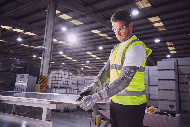 Worker wearing HyFlex® 11-581 mechanical gloves engages in metallurgy tasks, handling metal materials with precision and safety