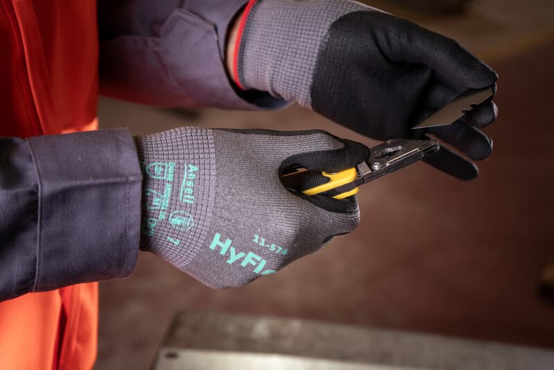 Worker using sharp tools while wearing HyFlex 11-574 gloves for cut protection and precision handling