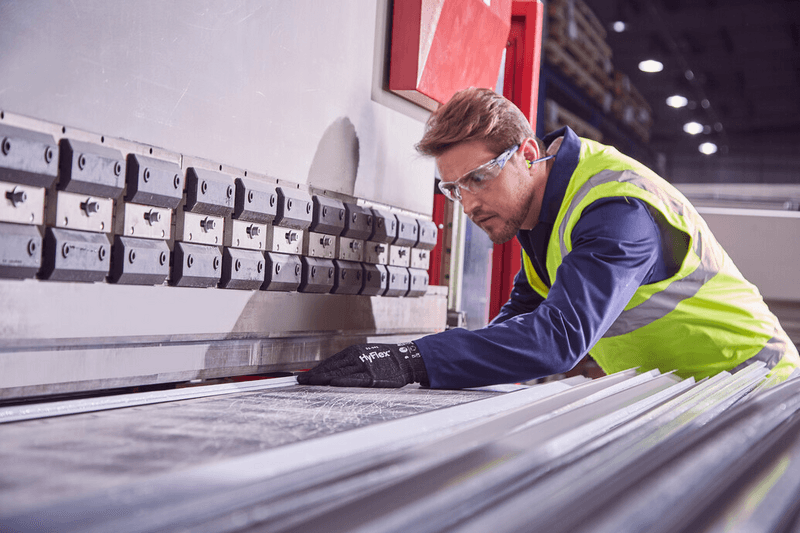 Operator wearing HyFlex® 11-591 mechanical gloves handles a panel, ensuring safe grip and careful positioning