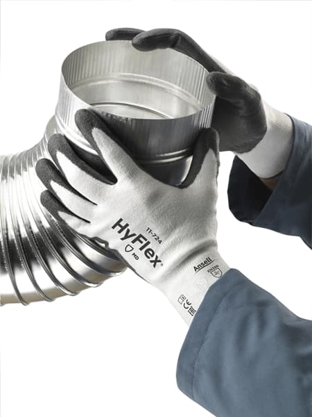 Hand wearing HyFlex 11-724 glove, holding a tube
