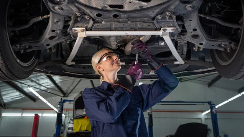 Mechanic wearing mechanical EDGE 48-393 gloves works on a car engine, ensuring precision and safety.