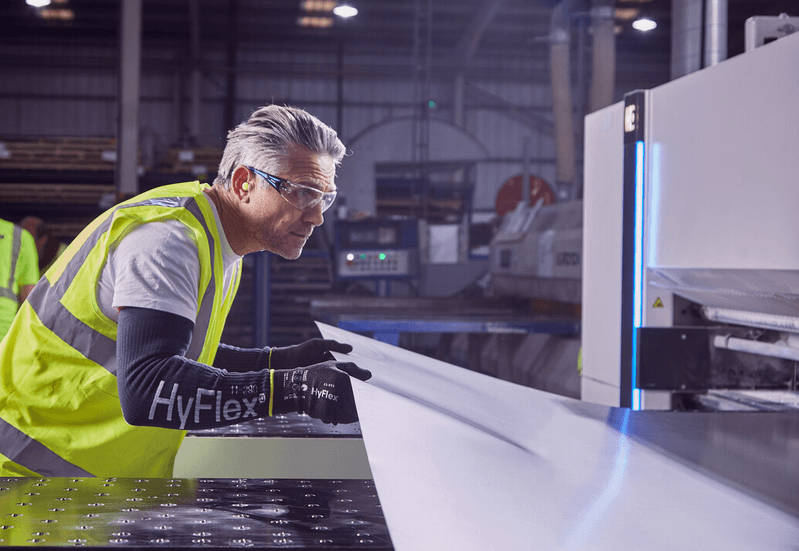 Operator wearing HyFlex® 11-591 mechanical gloves handles a panel, ensuring safe grip and careful positioning