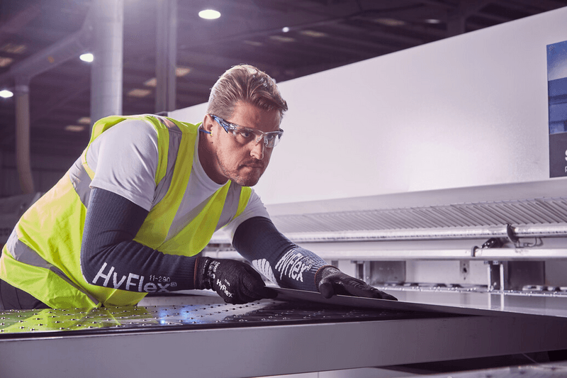 Operator wearing HyFlex® 11-591 mechanical gloves handles a panel, ensuring safe grip and careful positioning